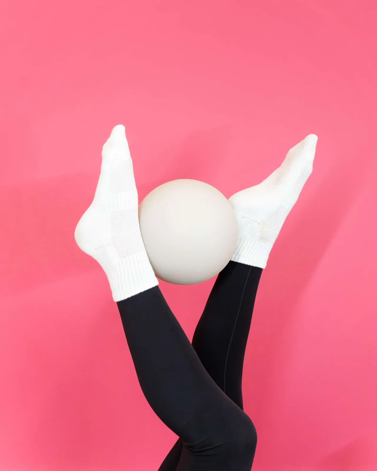 Pilates ball held between the feet